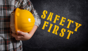 An image of a person holding a hardhat against their body, with text reading "safety first"