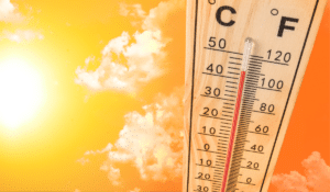 An image of a scorching sun, and a thermometer indicating 100 degree weather, signaling the need for a workplace heat standard.