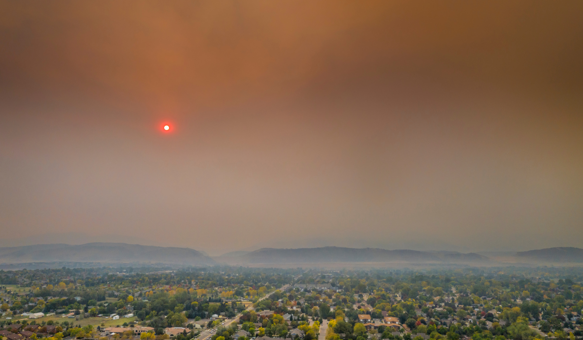 Wildfire smoke hanging over a landscape, nearly blocking out the sun