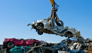 A crane lifting a crushed car at an auto recycling facility. NJ auto recycler was fined $868K for 35 OSHA violations